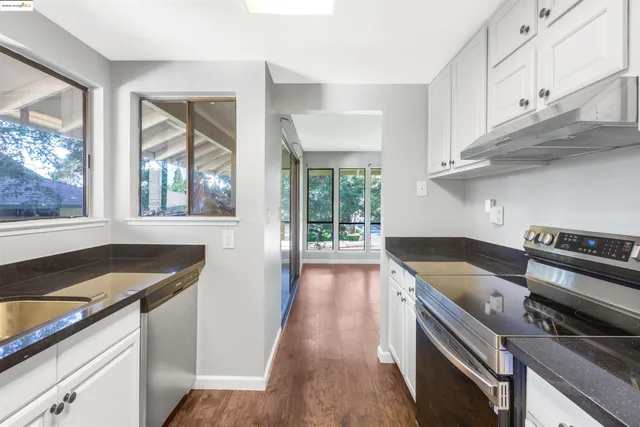 a kitchen with granite countertop a stove and a sink