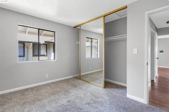 an empty room with windows and closet