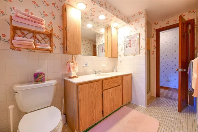 a bathroom with a granite countertop toilet sink and mirror