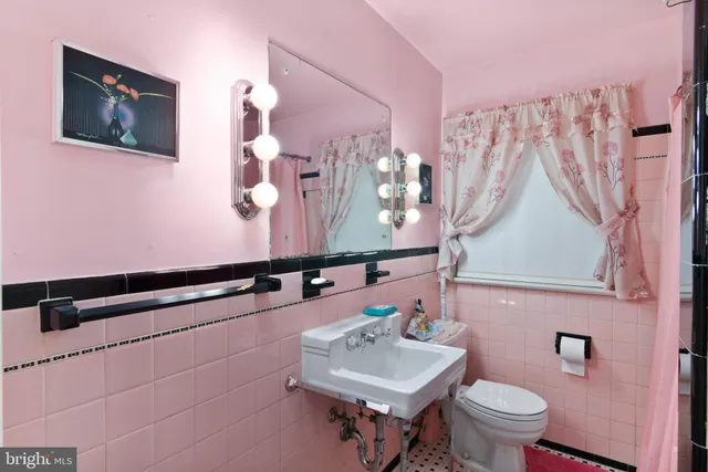 a bathroom with a sink mirror and toilet