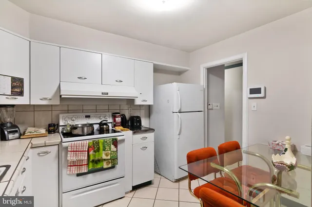a kitchen with stainless steel appliances granite countertop a refrigerator sink and white cabinets