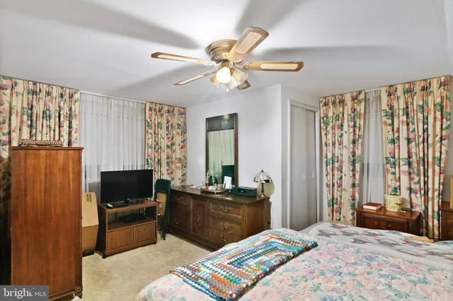 a bedroom with a bed a window and a flat screen television