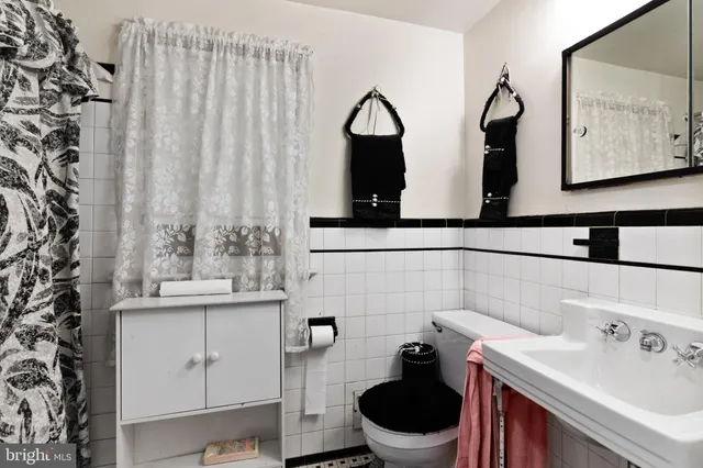 a bathroom with a toilet sink and mirror