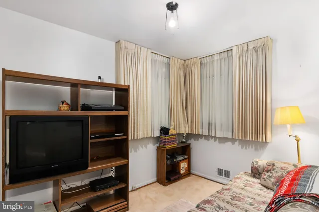 a bedroom with bed and a flat tv screen on a dresser