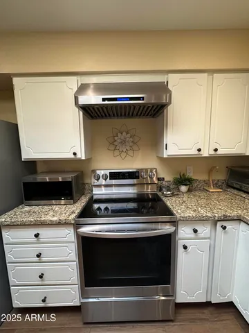 a open kitchen with stainless steel appliances granite countertop a stove a sink and cabinets