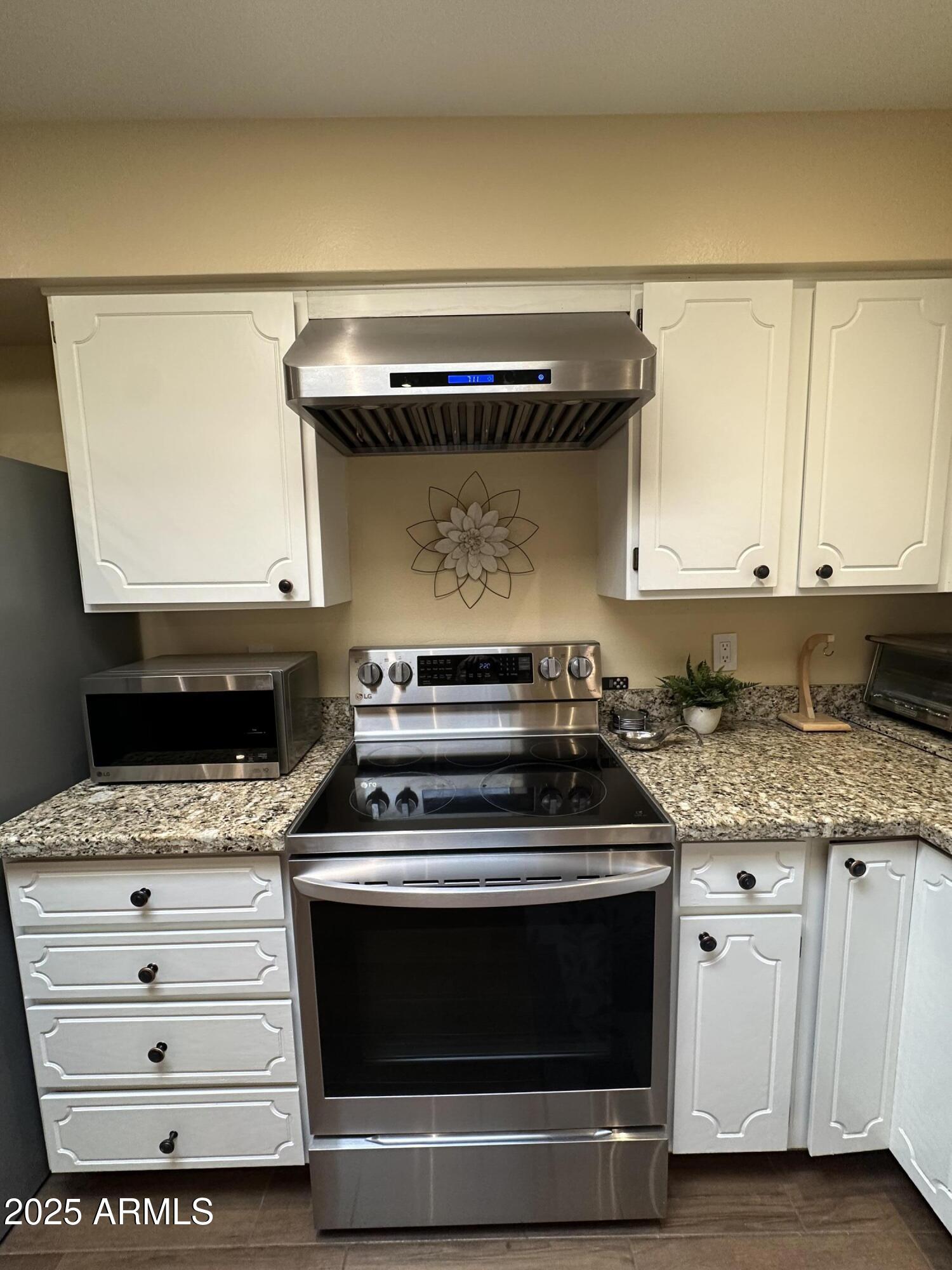 4328 East Capri Avenue, Unit 180 Mesa, AZ 85206 - Photo 11 of 38 a stove top oven sitting inside of a kitchen