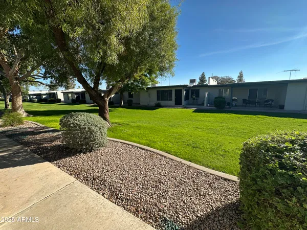 a view of a livingroom with furniture wooden floor a flat screen tv and a window