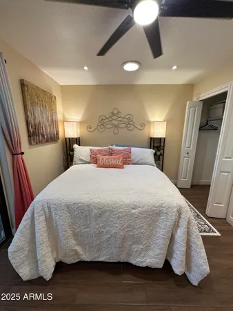 a bed sitting in a bedroom next to a window with pc on the table