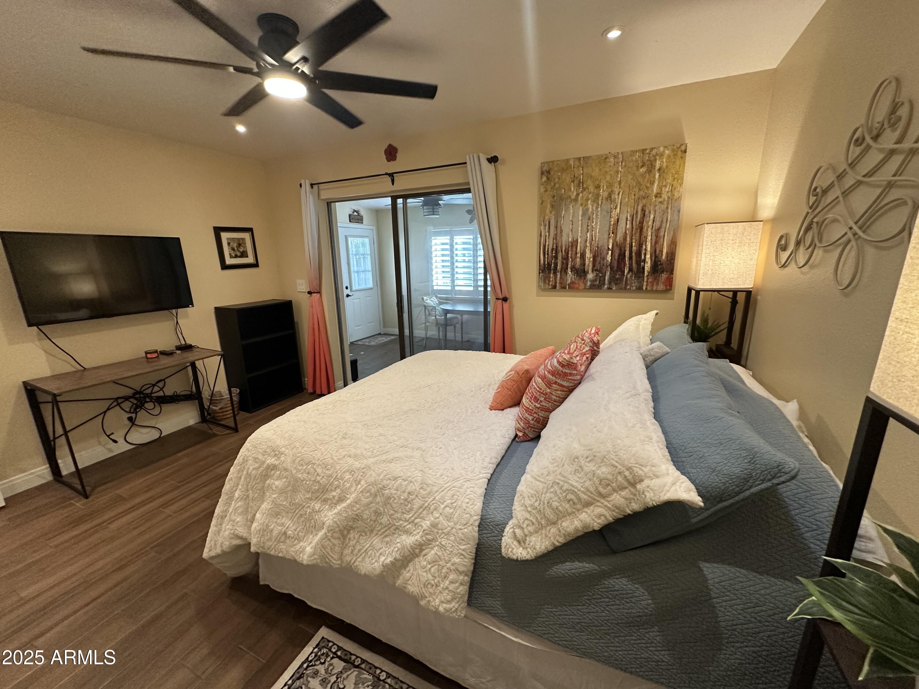 4328 East Capri Avenue, Unit 180 Mesa, AZ 85206 - Photo 22 of 38 a bed sitting in a bedroom next to a window with pc on the table