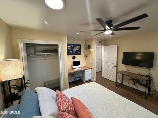 a bedroom with a bed window and a flat screen tv