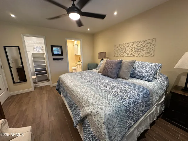 a bedroom with a bed a couch and a chandelier