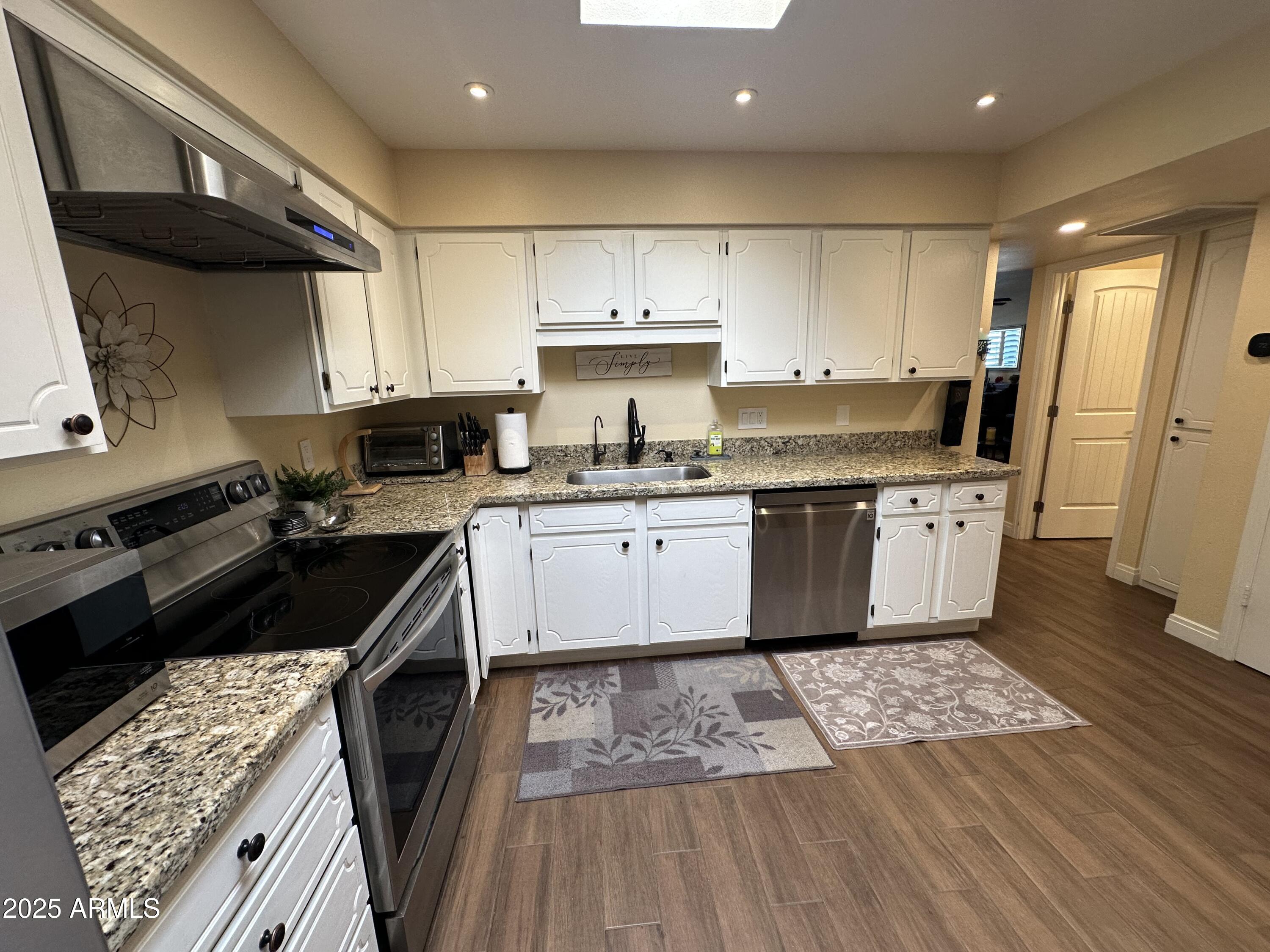 4328 East Capri Avenue, Unit 180 Mesa, AZ 85206 - Photo 9 of 38 a kitchen with a sink stove and cabinets