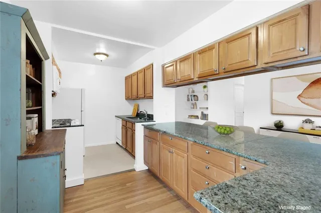 a kitchen with granite countertop stainless steel appliances a sink a stove and cabinets