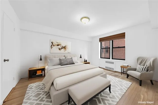 a bedroom with a large bed couch and a window