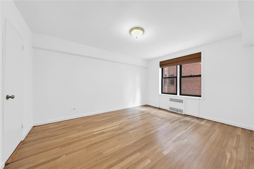7401 Shore Road, Unit 2A Brooklyn, NY 11209 - Photo 19 of 22 an empty room with wooden floor and windows