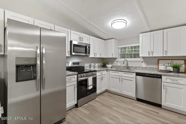a kitchen with granite countertop a sink and a white stainless steel appliances
