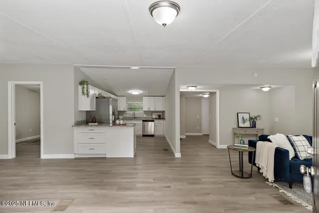 a living room with furniture a chandelier and a wooden floor