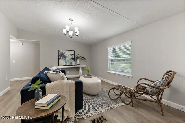 a living room with furniture and a chandelier