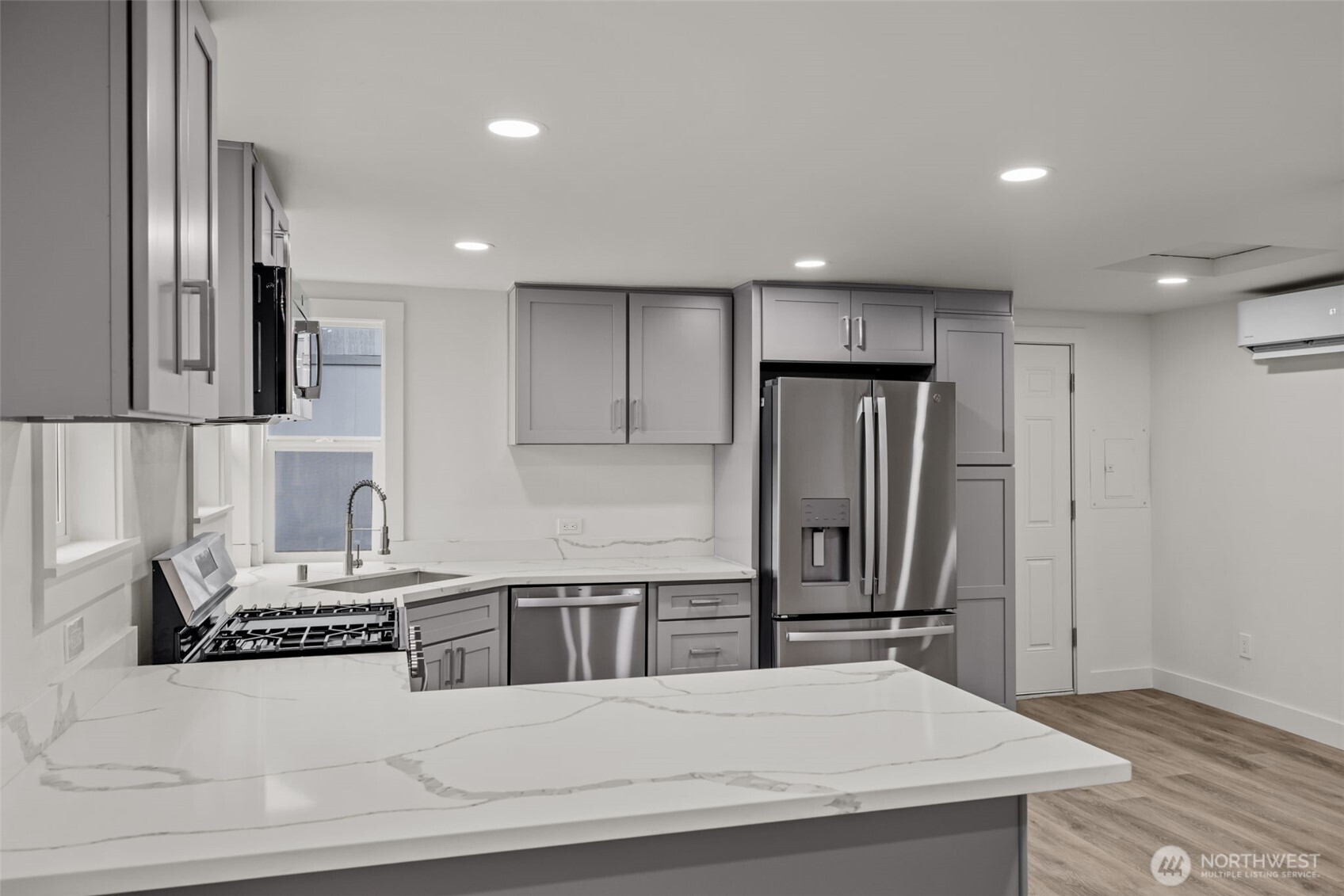 1521 North 3rd Street Renton, WA 98057 - Photo 13 of 18 a kitchen with stainless steel appliances kitchen island granite countertop a refrigerator a stove and a sink with wooden floor