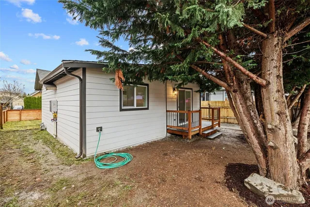 a backyard of a house with barbeque oven and large trees