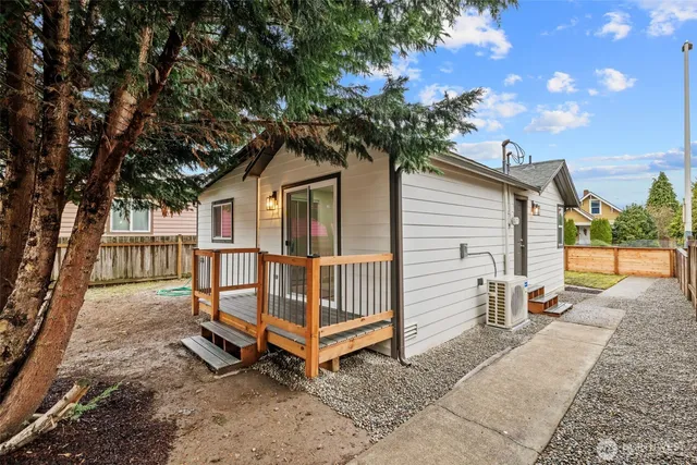 a white house that has a tree in front of it