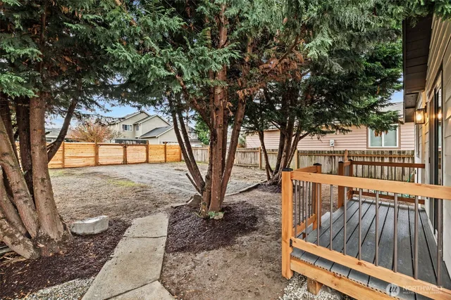 a view of backyard with deck and wooden fence