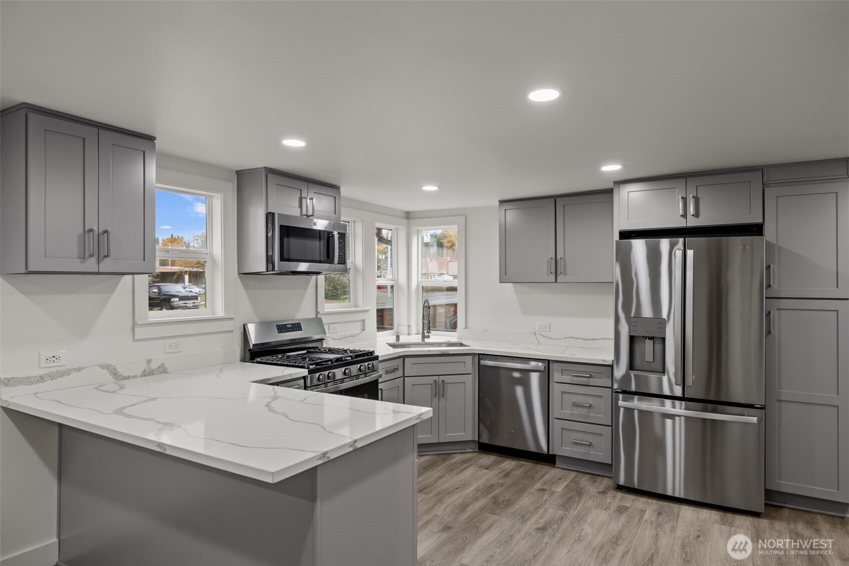 1521 North 3rd Street Renton, WA 98057 - Photo 4 of 18 a kitchen with a sink a stainless steel refrigerator and cabinets