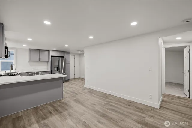 a large kitchen with a sink and a refrigerator