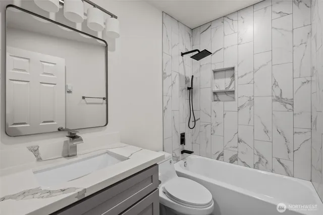 a bathroom with a granite countertop sink toilet and shower