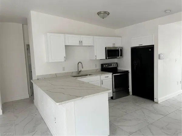 a kitchen that has a sink and a stove in it