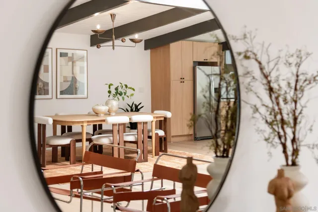 a kitchen with stainless steel appliances granite countertop a stove a refrigerator a dining table and chairs with wooden floor