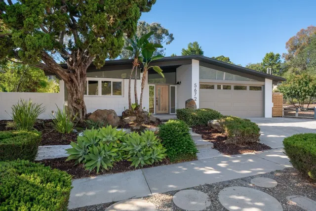 a living room with furniture a chandelier and a dining table