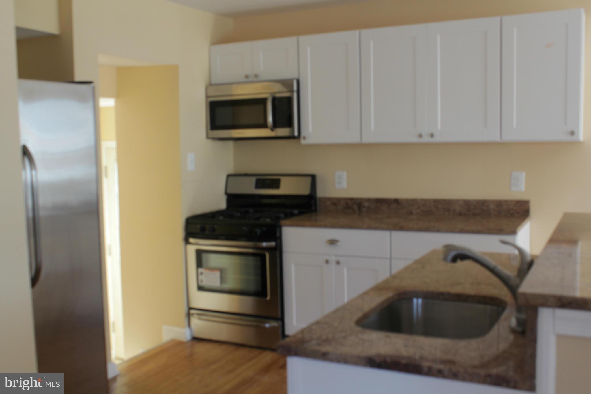 8129 Old Philadelphia Road Baltimore, MD 21237 - Photo 3 of 25 a kitchen with a sink cabinets and stainless steel appliances