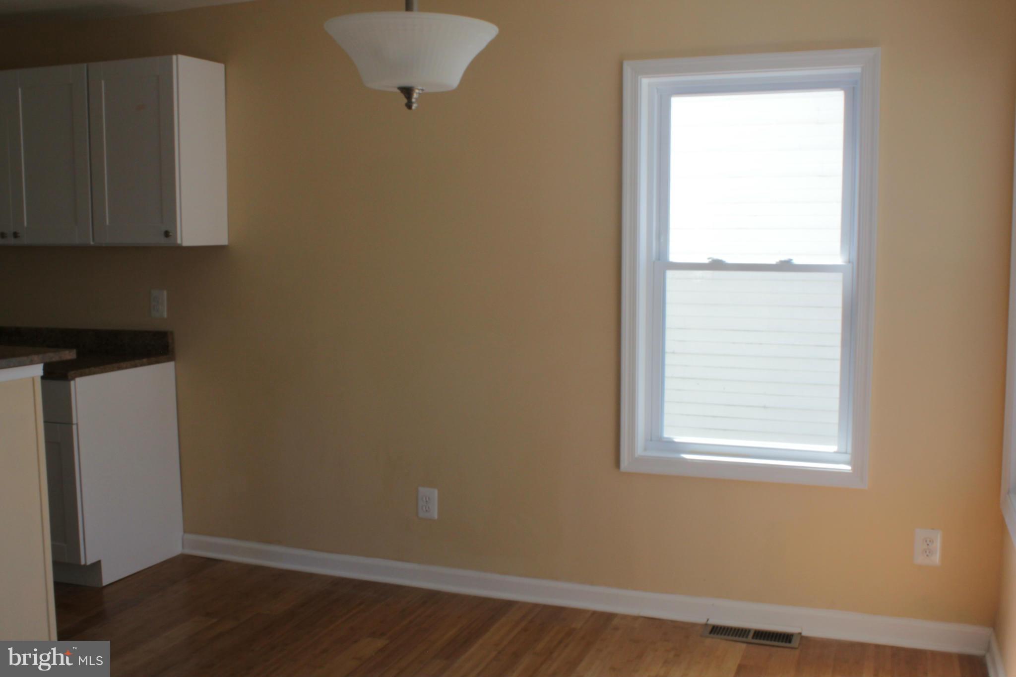 8129 Old Philadelphia Road Baltimore, MD 21237 - Photo 6 of 25 a view of an empty room with wooden floor and a window