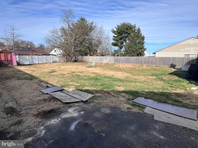a view of a yard with wooden fence