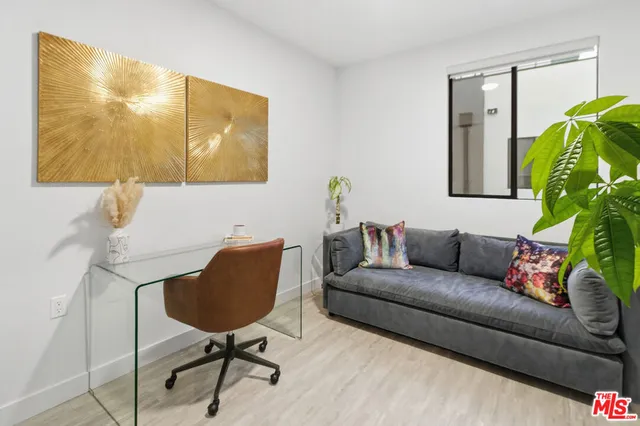 a living room with furniture and a painting on the wall