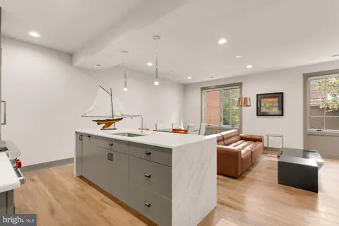 a view of a kitchen counter top space with sink stainless steel appliances and windows