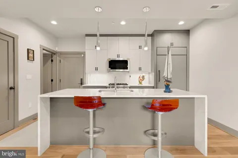 a kitchen with stainless steel appliances granite countertop a sink and a refrigerator