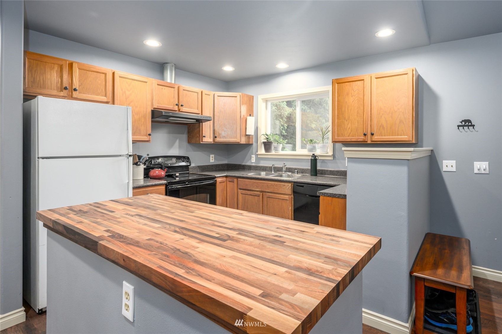 719 W Road Sedro-Woolley, WA 98284 - Photo 8 of 22 a kitchen with stainless steel appliances granite countertop a refrigerator a sink dishwasher a stove and white countertops with wooden floor