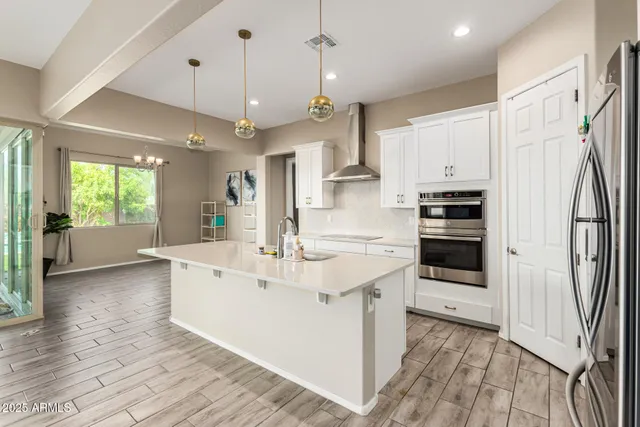 a kitchen with stainless steel appliances kitchen island granite countertop a sink stove and refrigerator