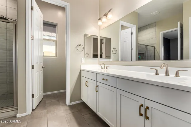 a bathroom with a double vanity sink mirror and next to a white cabinet