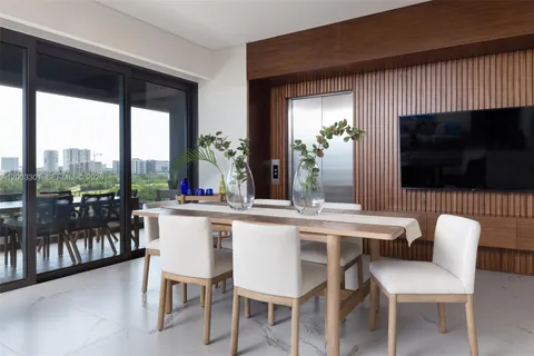 a dining room with furniture a flat screen tv and a large window