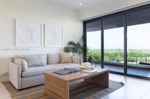 a living room with furniture large window and a potted plant