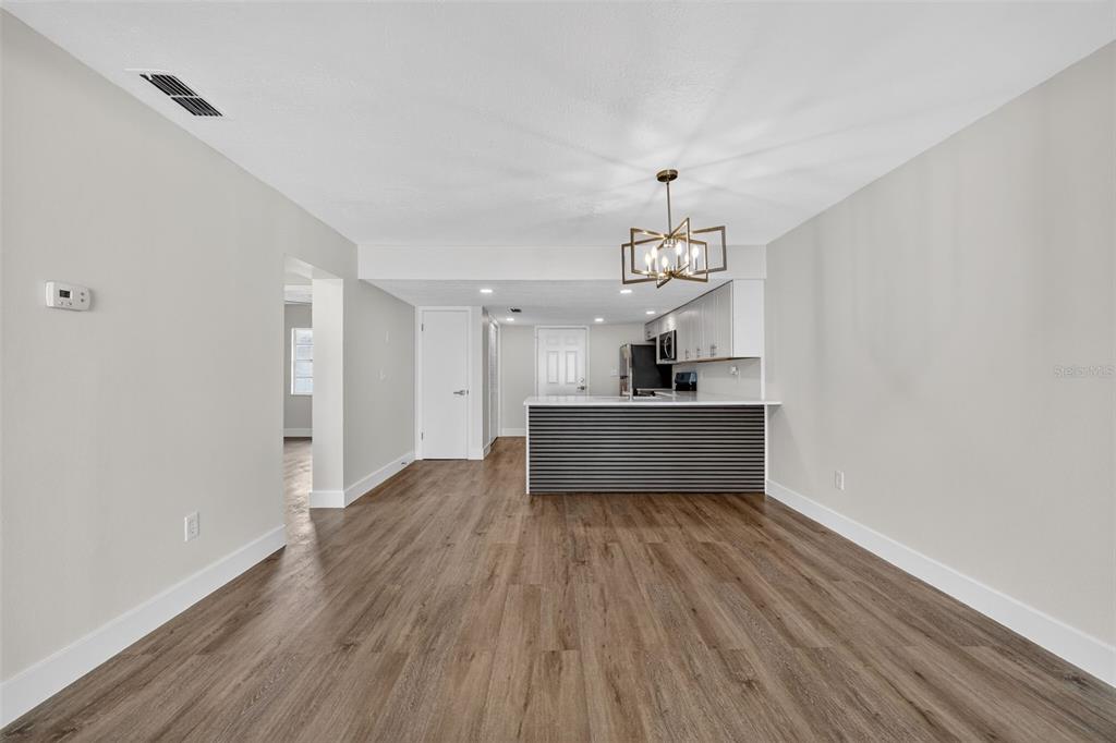 9826 Pocono Street Port Richey, FL 34668 - Photo 3 of 15 a view of a room with wooden floor staircase and a kitchen