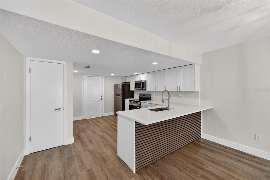 9826 Pocono Street Port Richey, FL 34668 - Photo 5 of 15 a kitchen with stainless steel appliances granite countertop a sink stove and wooden floor