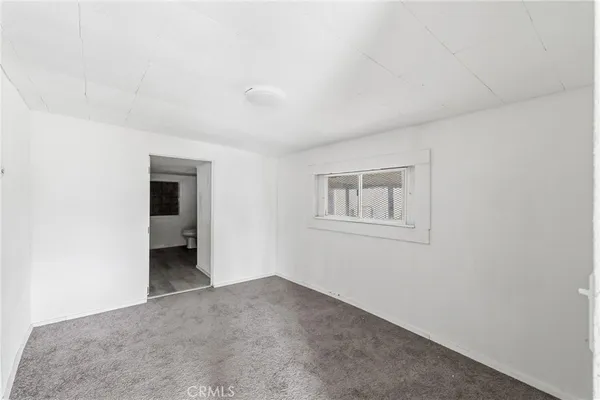 a view of a room with a hallway and closet