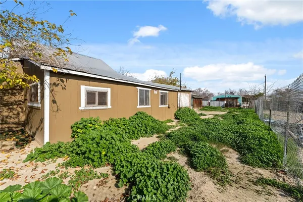a view of a house with a yard and potted plants