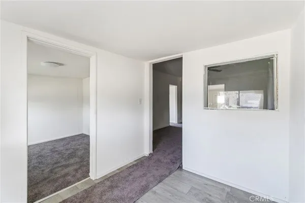 a hallway with two mirrors and a refrigerator