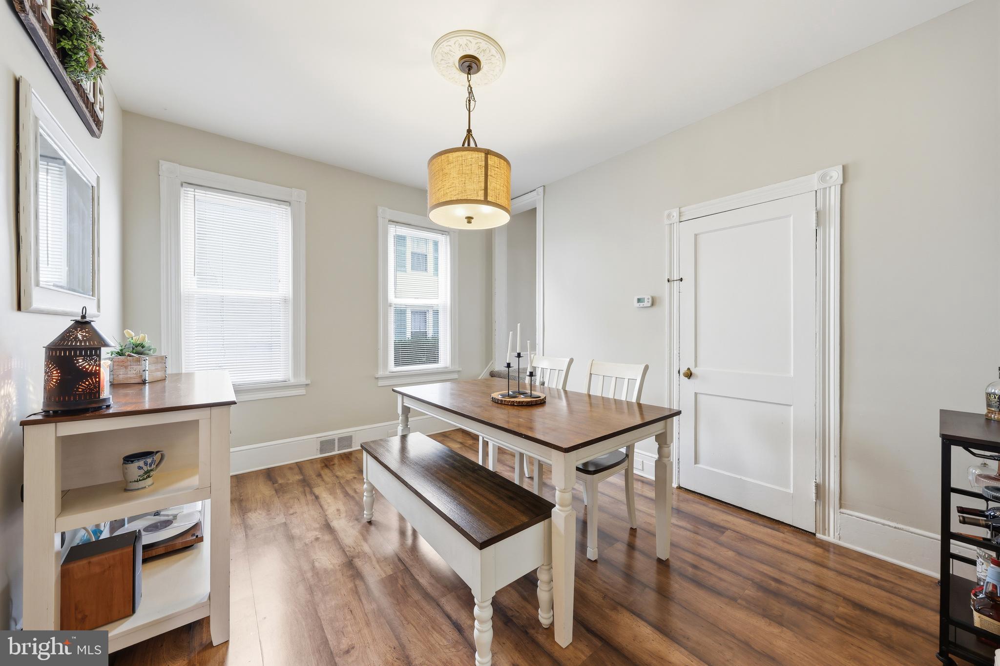 212 Grape Street Hammonton, NJ 08037 - Photo 15 of 36 a dining room with wooden floor a chandelier a wooden table and chairs