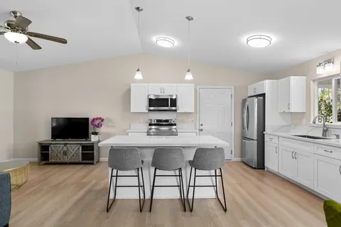 a kitchen with stainless steel appliances a stove a refrigerator and a dining table